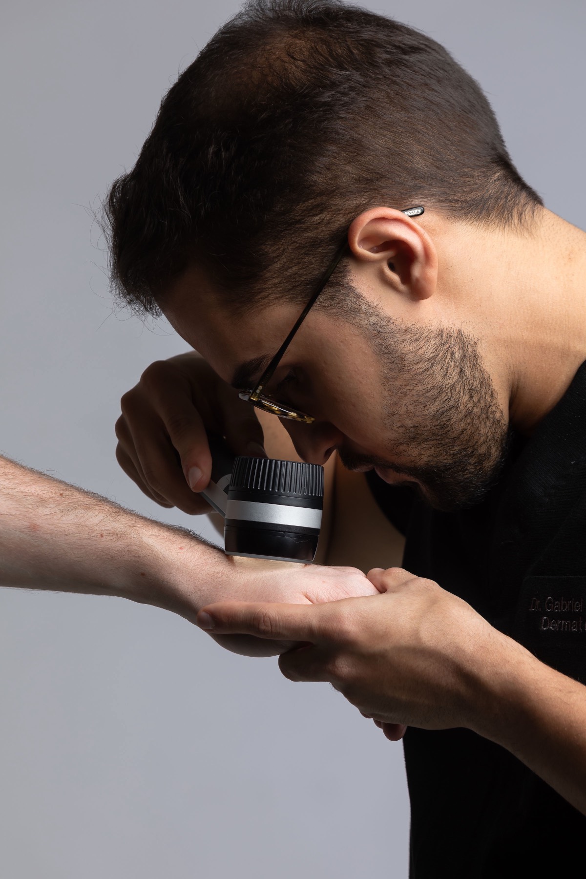 Avaliação de lesão no braço com dermatoscópio